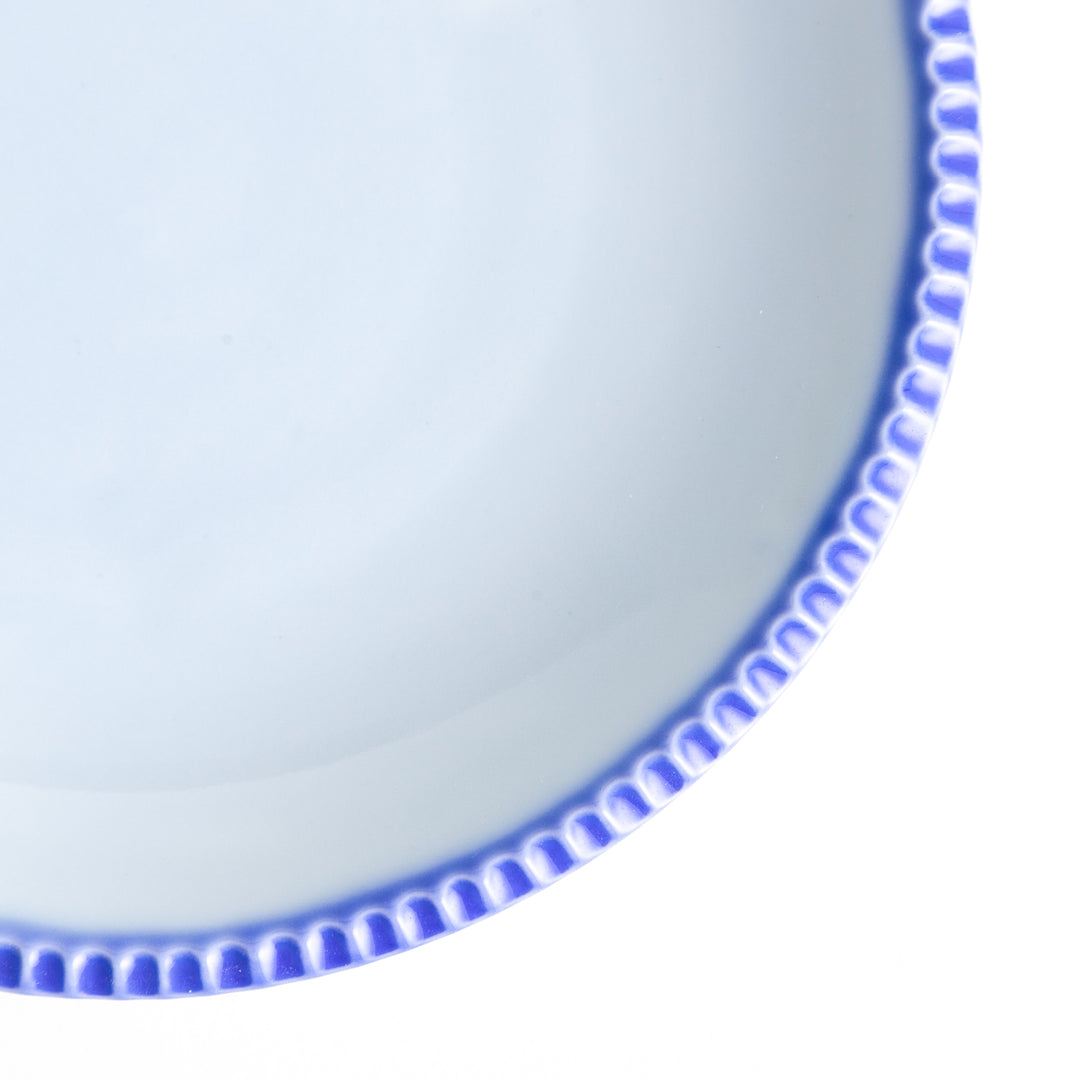 A round white dessert plate with a rustic scallop-edged border. The border comes in blue, brown, and olive.