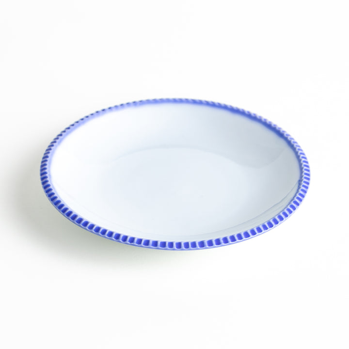 A round white dessert plate with a rustic scallop-edged border. The border comes in blue, brown, and olive.