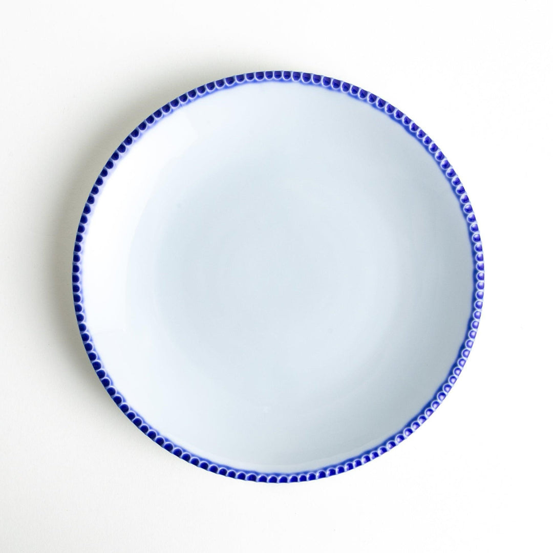 A round white dinner plate with a rustic scallop-edged border. The border comes in blue, brown, and olive.