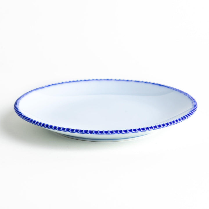 A round white dinner plate with a rustic scallop-edged border. The border comes in blue, brown, and olive.