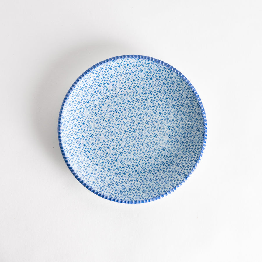 A plate with a delicate blue sesame pattern, perfect for adding elegance to any meal. The plate features an intricate blue design.