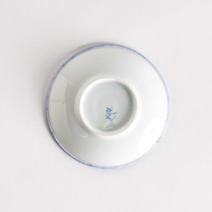 A round ceramic plate with a delicate blue floral pattern, bordered by a textured rim.