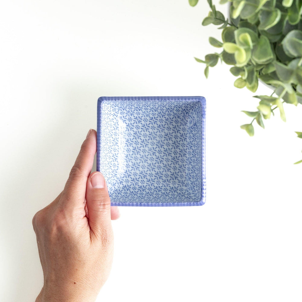 A square bowl with a blue geometric pattern and a light blue rim.