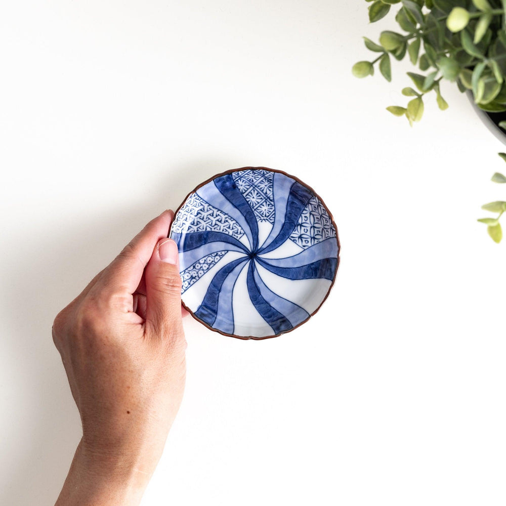 A small round plate featuring a blue swirl design with Mount Fuji background.