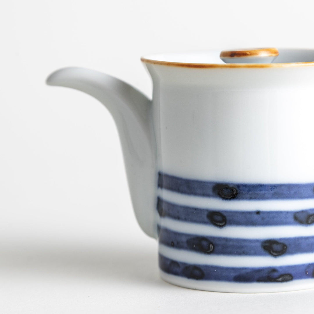 A small white ceramic soy sauce dispenser featuring blue horizontal stripes.