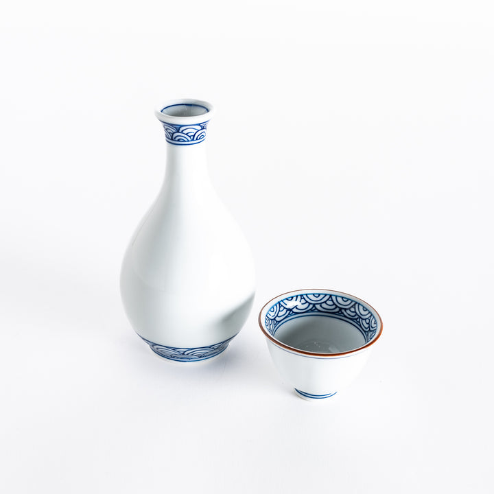 Front view of a white porcelain sake flask and cup set featuring elegant blue wave patterns.