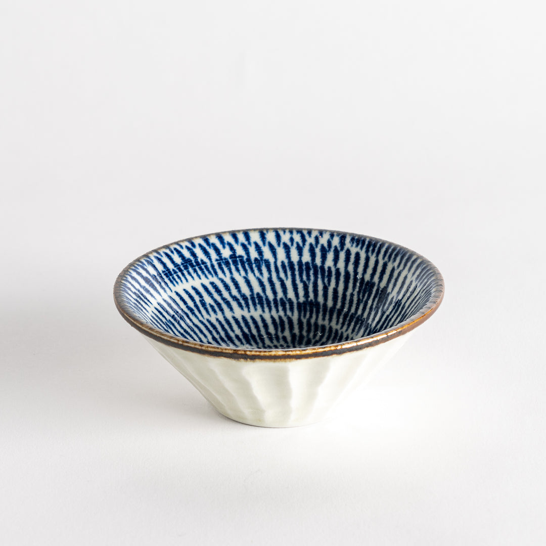 A small, shallow bowl with a flared edge, decorated with blue brushstroke patterns.