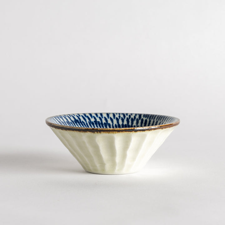 A small, shallow bowl with a flared edge, decorated with blue brushstroke patterns.