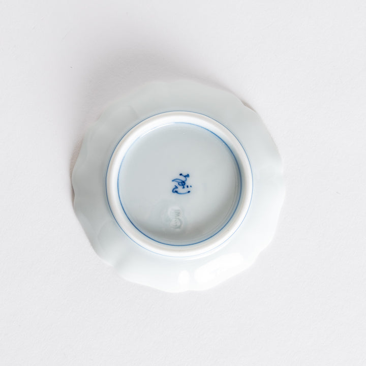 The underside of a ceramic dish, showing its smooth finish and blue markings, characteristic of fine porcelain craftsmanship.