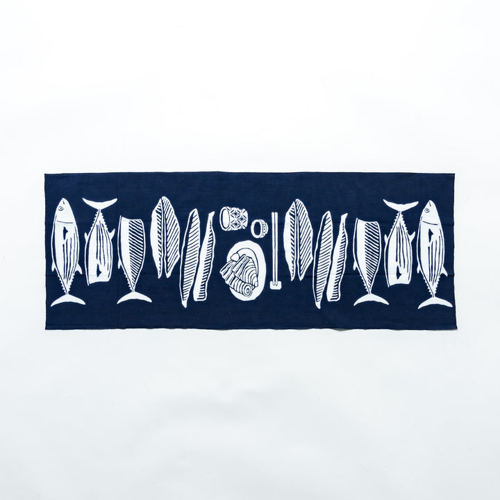 Fully spread navy tenugui hand towel showcasing white fish and wave illustrations.