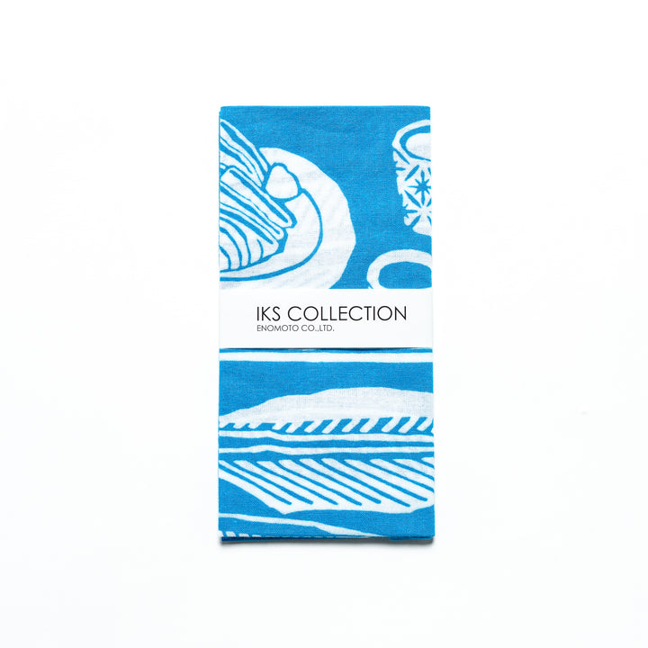 Light blue tenugui, folded with a product sleeve highlighting white fish designs.