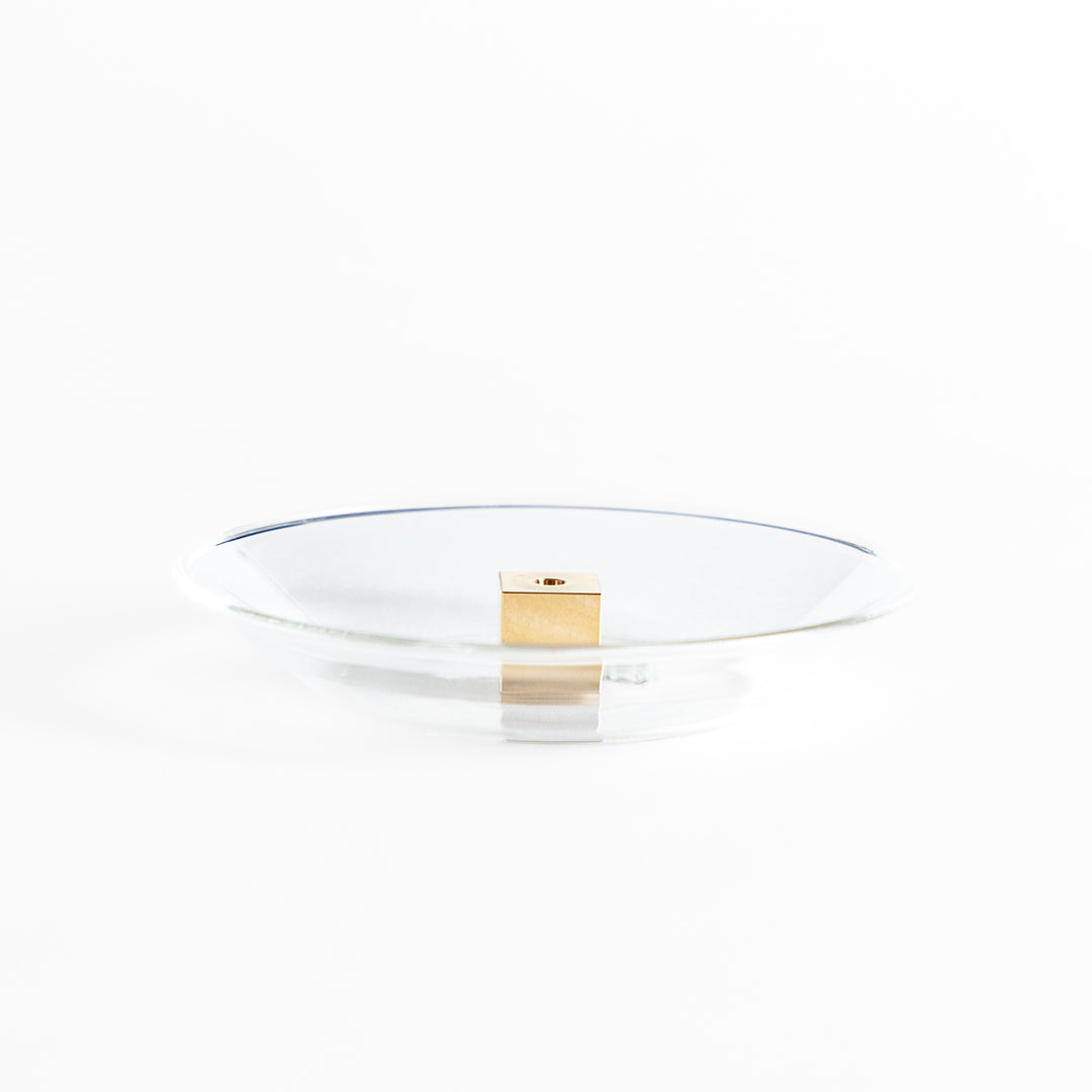 A modern Incense Holder set featuring a transparent glass dish and a brass cube stand, combining minimalist aesthetics with functionality for a refined incense experience.