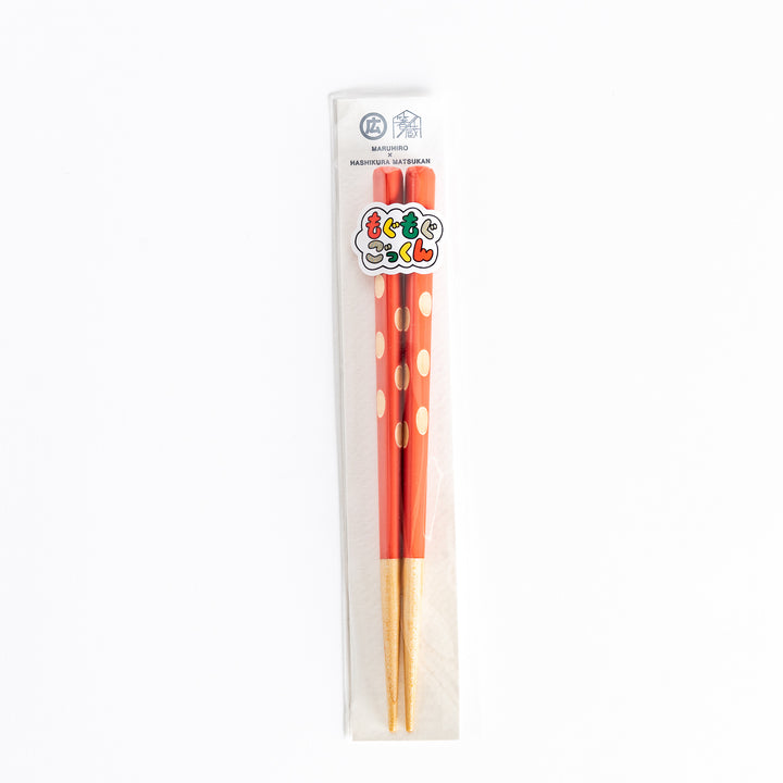  Red children’s chopsticks with beige dots, packaged in clear plastic, displaying the brand logo.