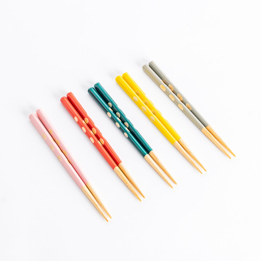 A colorful set of children's chopsticks in pink, red, green, yellow, and gray, featuring playful dot patterns and wooden tips, ideal for little hands.