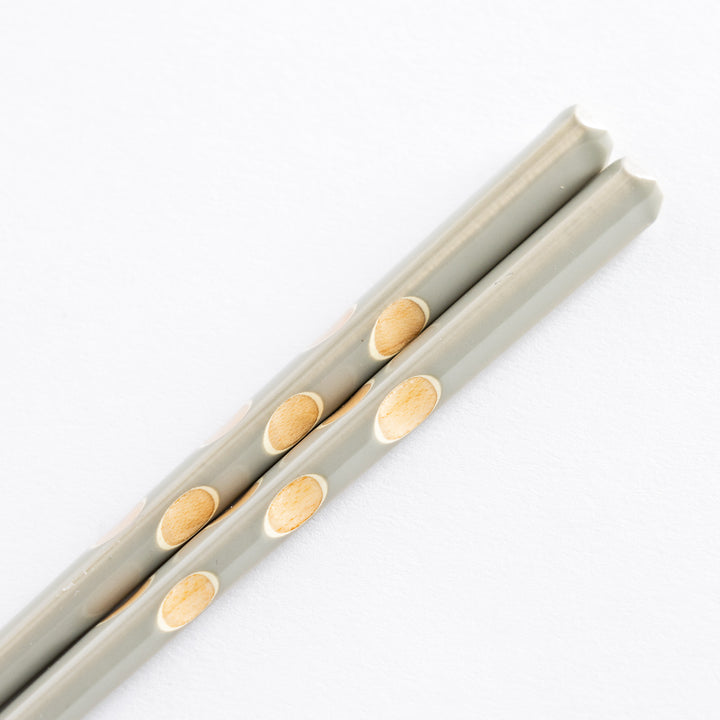 Detailed view of gray chopsticks highlighting the polka dot design on the surface.