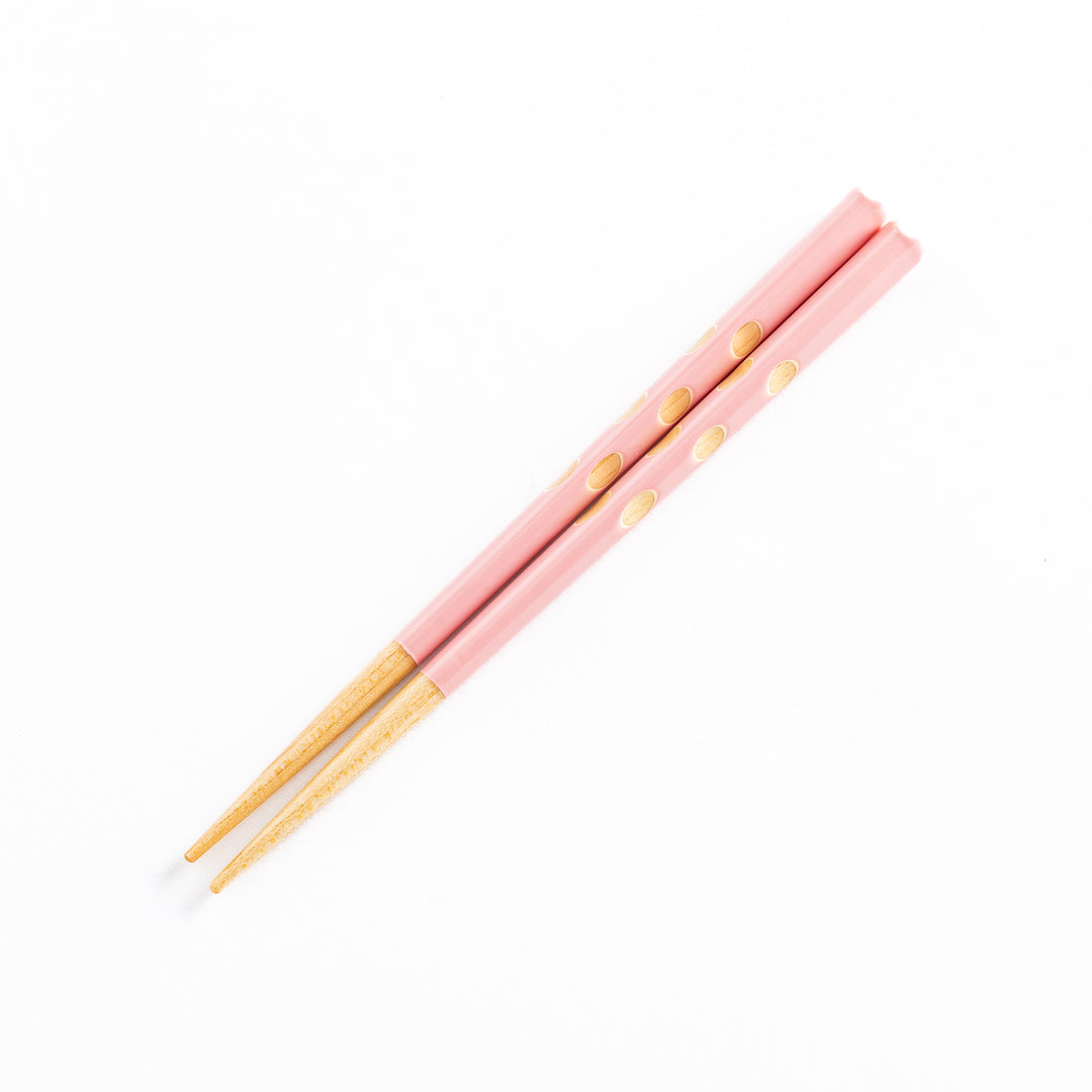 Top view of pink children's chopsticks, highlighting the dotted design.