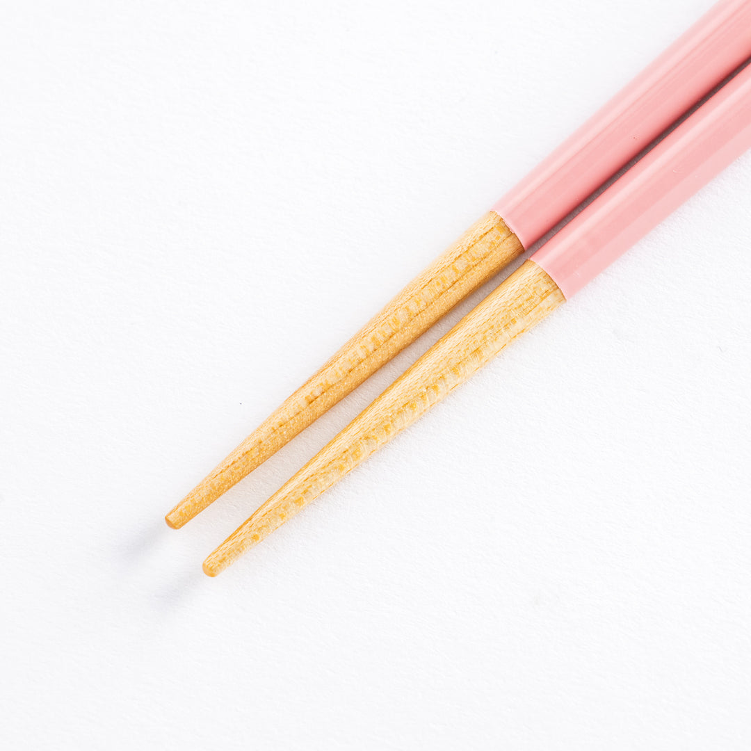 Detail of the wood tip ends of pink children’s chopsticks.