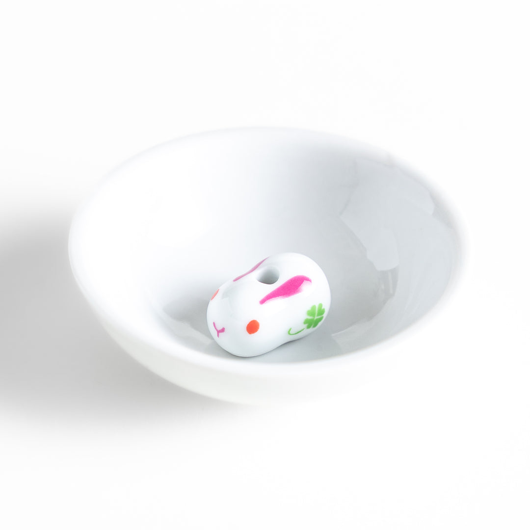 White ceramic incense holder featuring an adorable rabbit-shaped stand with pink and green accents, offering a charming and elegant way to enjoy incense while enhancing any space.