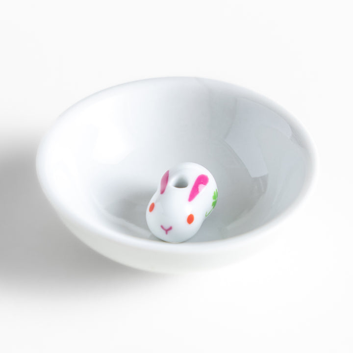 White ceramic incense holder featuring an adorable rabbit-shaped stand with pink and green accents, offering a charming and elegant way to enjoy incense while enhancing any space.