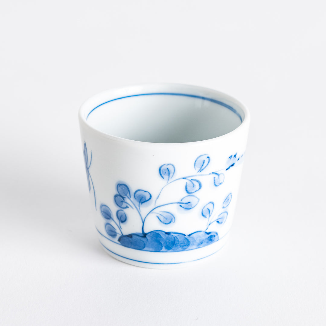 A white condiment bowl decorated with blue bush clover patterns around the side, ideal for small servings or sauces.