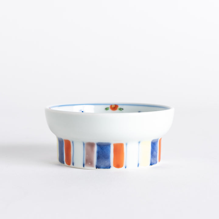 A petite raised sauce dish featuring colorful butterflies and floral designs, with multicolored vertical stripes along the base.