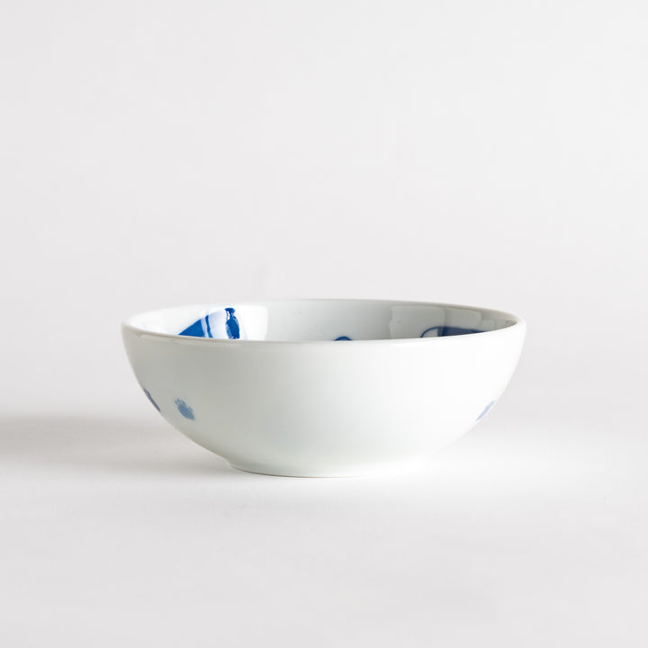 A dessert bowl featuring a playful blue and white cat with a relaxed expression.