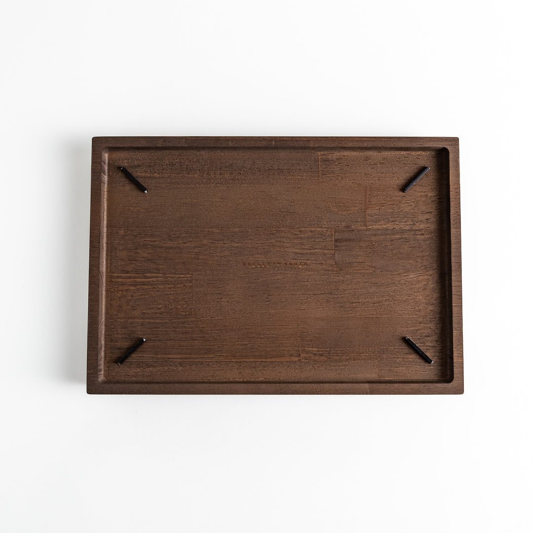 Dark wooden board with notched corners, showcasing a natural grain pattern.