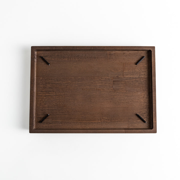 Dark wooden board with notched corners, showcasing a natural grain pattern.