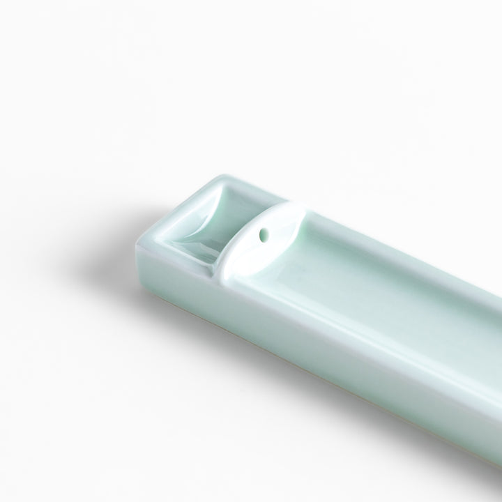 Incense Holder in a sleek celadon ceramic design with a built-in slot for holding sticks, featuring a rectangular shape that elegantly catches falling ash.