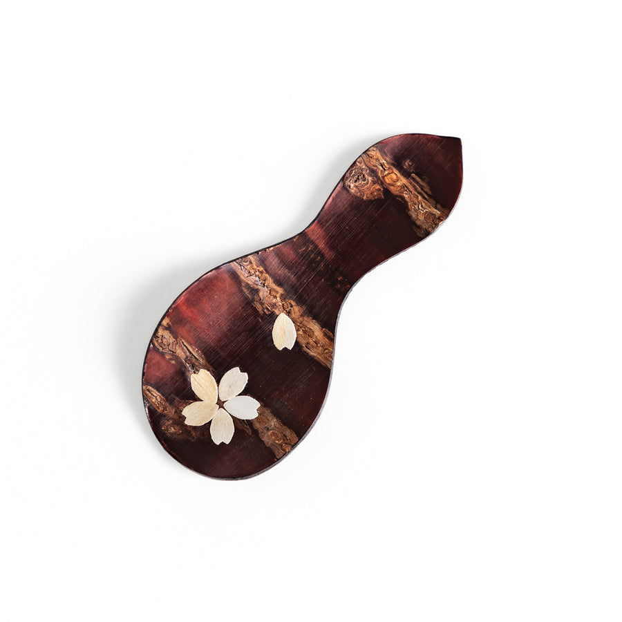 Handcrafted cherry bark tea scoop with a delicate cherry blossom inlay, perfect for measuring loose leaf tea with a touch of traditional elegance.