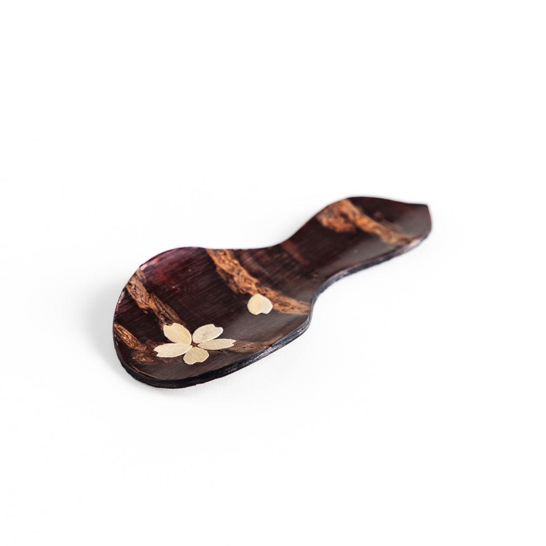 Handcrafted cherry bark tea scoop with a delicate cherry blossom inlay, perfect for measuring loose leaf tea with a touch of traditional elegance.