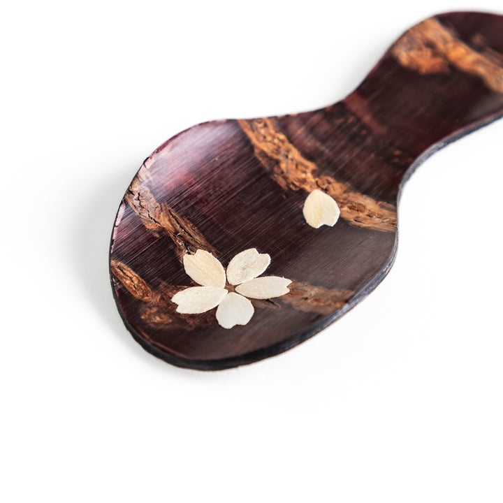 Handcrafted cherry bark tea scoop with a delicate cherry blossom inlay, perfect for measuring loose leaf tea with a touch of traditional elegance.