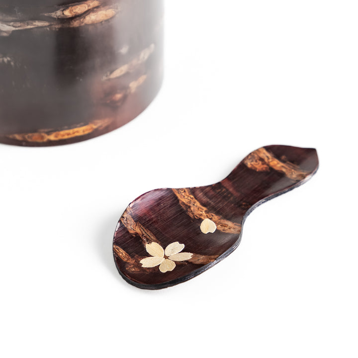 Handcrafted cherry bark tea scoop with a delicate cherry blossom inlay, perfect for measuring loose leaf tea with a touch of traditional elegance.