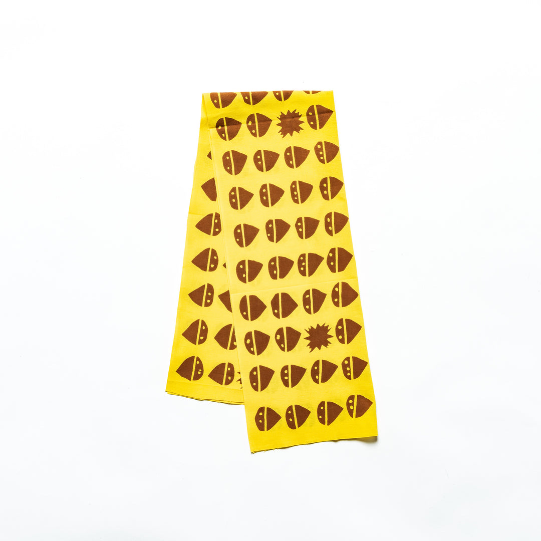 Yellow tenugui featuring a repeating brown chestnut pattern with occasional starburst designs.