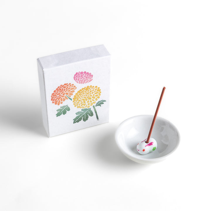 Incense featuring warm reddish-brown sticks in a box decorated with vibrant chrysanthemum flowers, offering a refined floral aroma for a calming atmosphere.