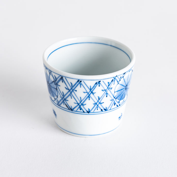 A small white condiment bowl with a delicate blue chrysanthemum and lattice pattern on the exterior.