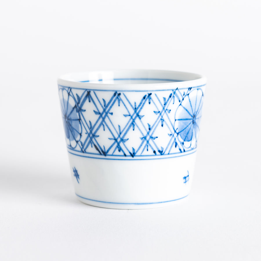 A small white condiment bowl with a delicate blue chrysanthemum and lattice pattern on the exterior.