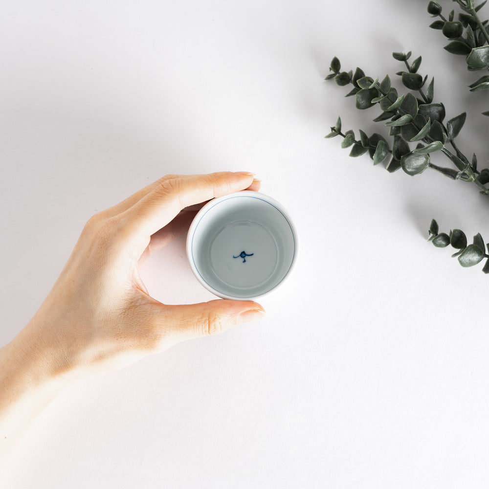 A small white condiment bowl with a delicate blue chrysanthemum and lattice pattern on the exterior.