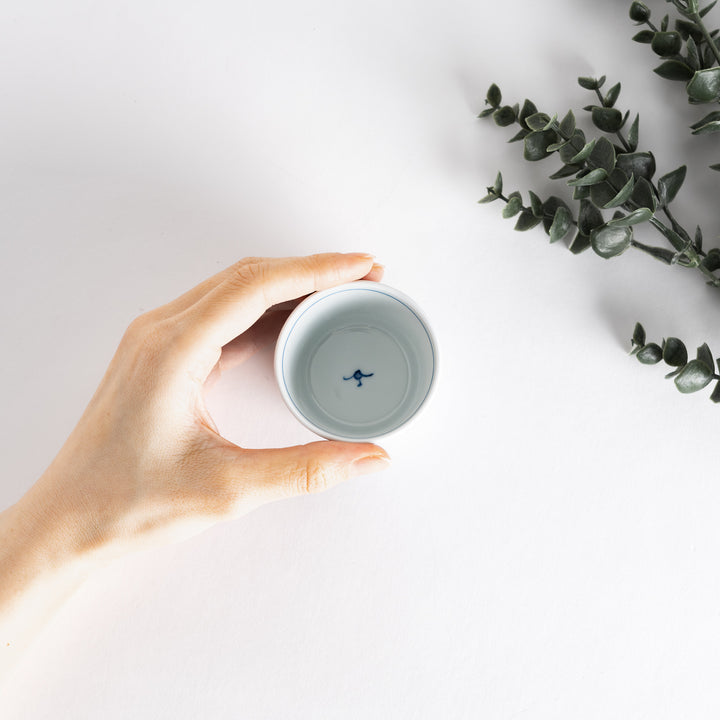 A small white condiment bowl with a delicate blue chrysanthemum and lattice pattern on the exterior.