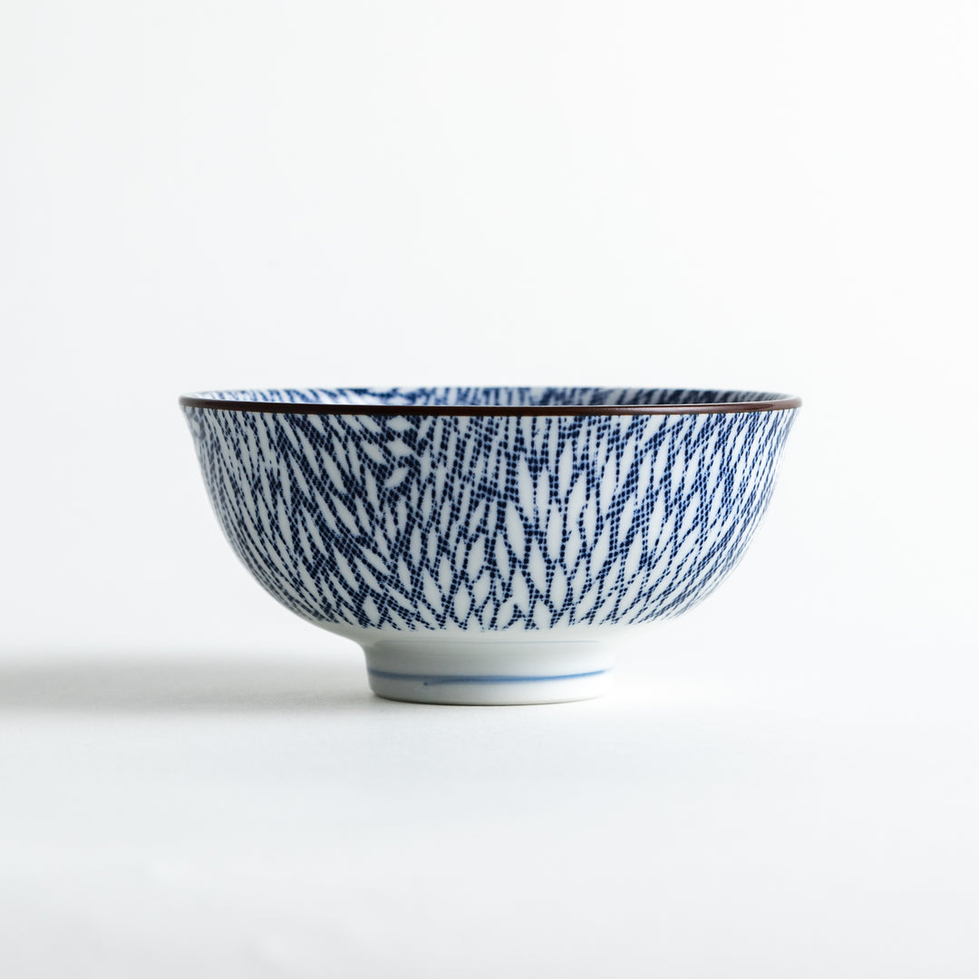 Side view of a white ceramic bowl featuring an intricate blue chrysanthemum leaves design on the surface.