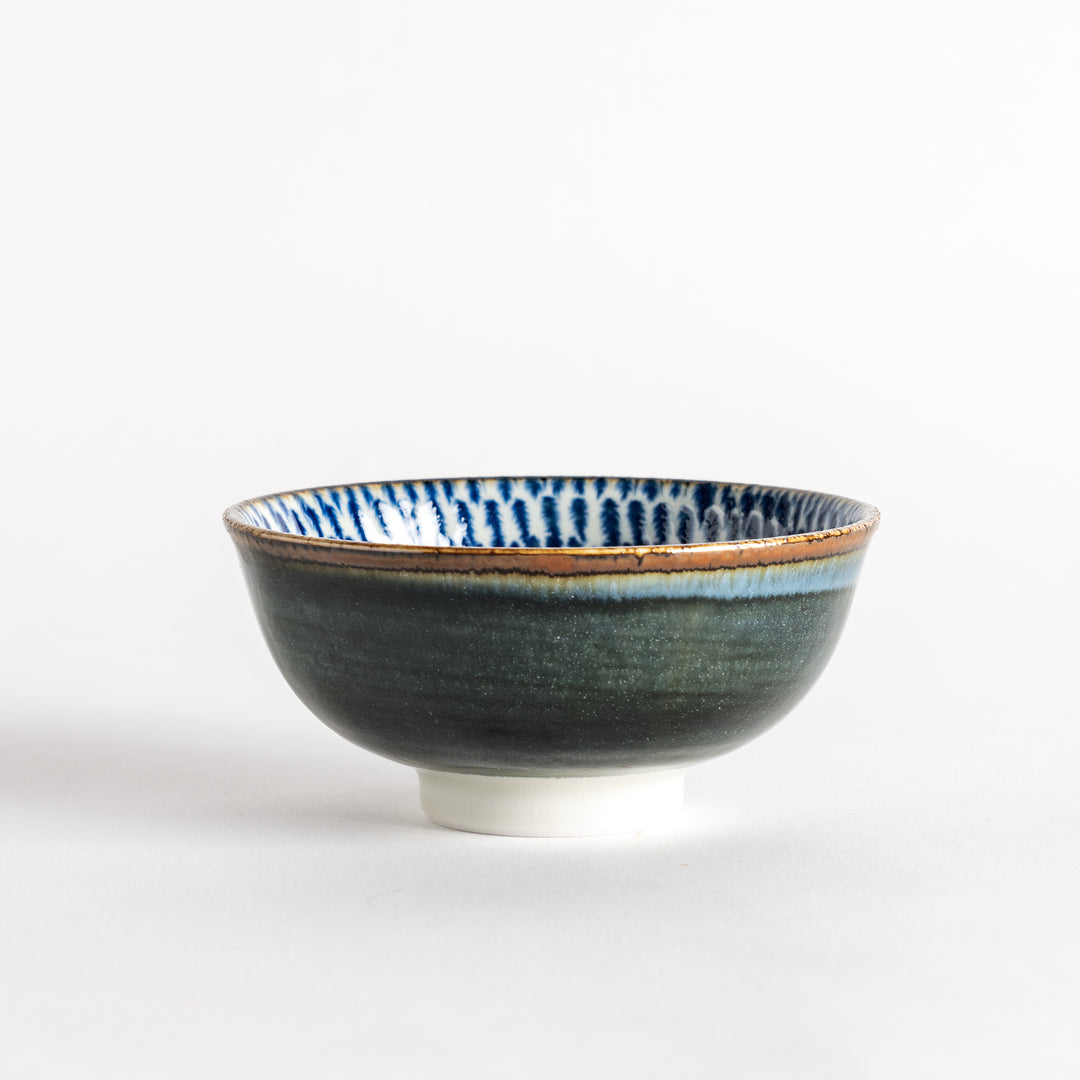 A round dessert bowl adorned with a sprial blue pattern spreading from the center.