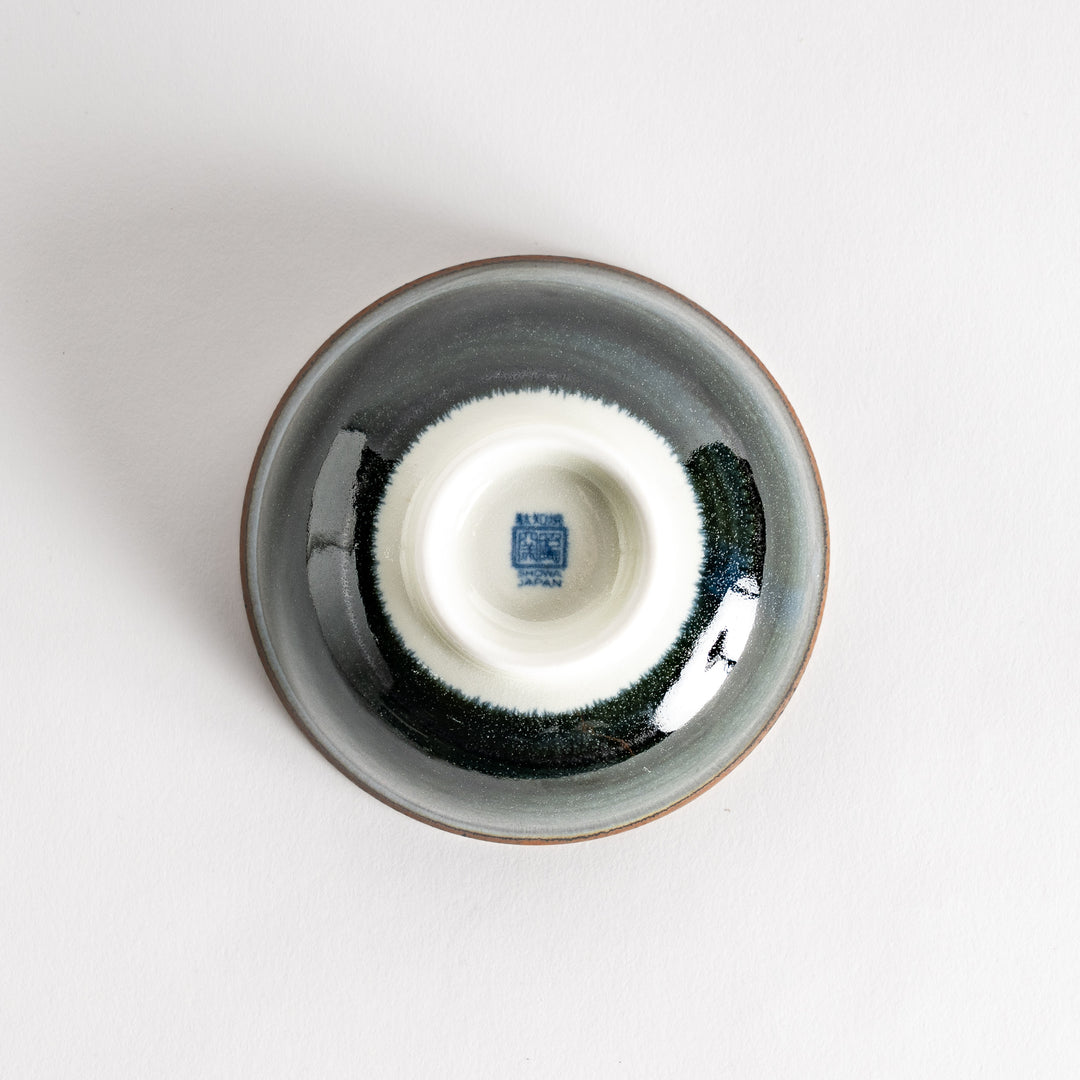 A round dessert bowl adorned with a sprial blue pattern spreading from the center.