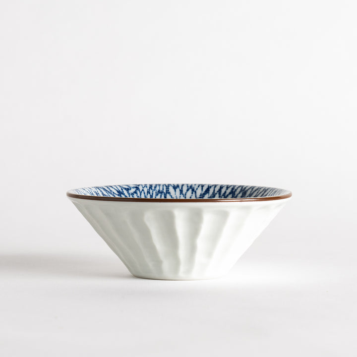 A small fluted bowl with a blue herringbone pattern on a white background.