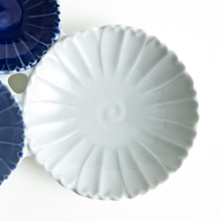 Tthree connected bowls in varying shades of blue and white, with a scalloped design.