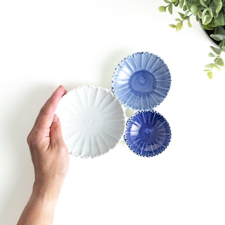 Tthree connected bowls in varying shades of blue and white, with a scalloped design.