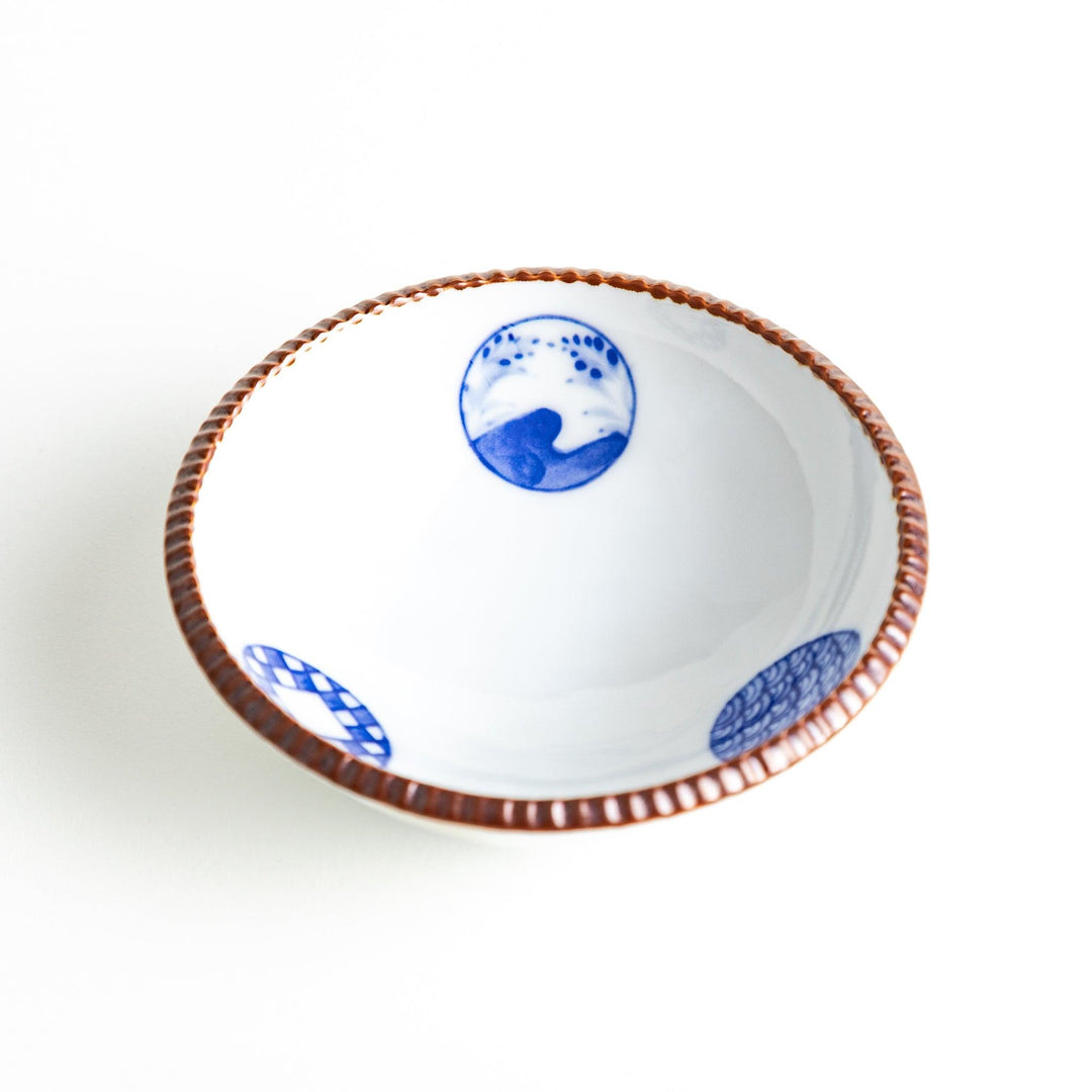 A dessert bowl featuring blue circular designs with a textured brown rim.