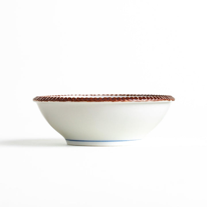 A dessert bowl featuring blue circular designs with a textured brown rim.