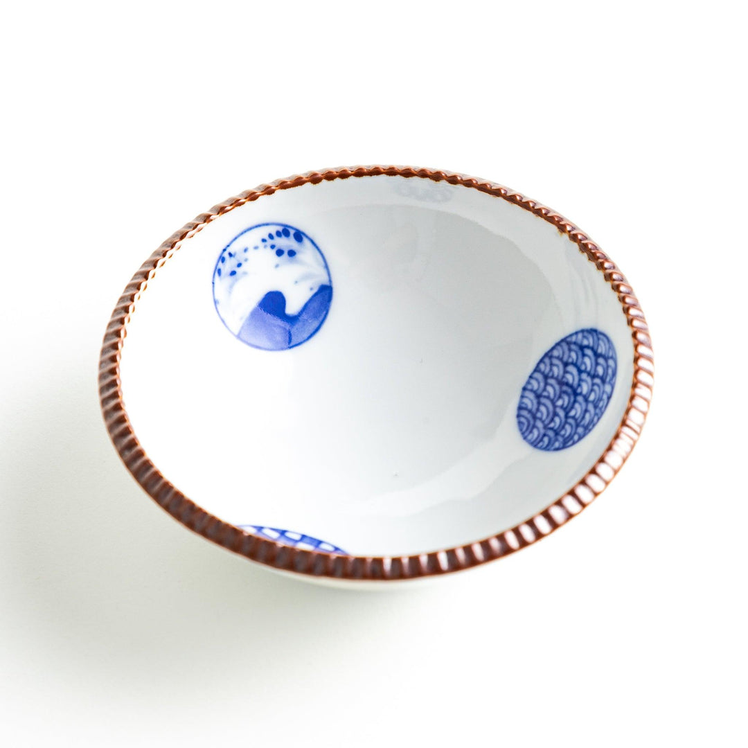 A dessert bowl featuring blue circular designs with a textured brown rim.