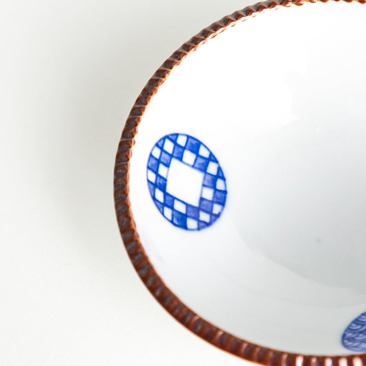 A dessert bowl featuring blue circular designs with a textured brown rim.