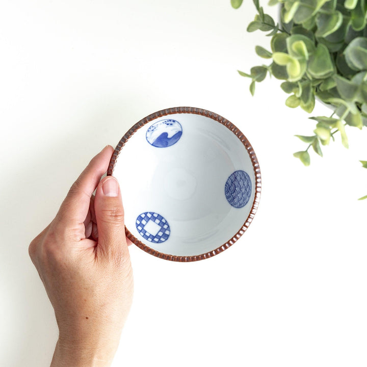 A dessert bowl featuring blue circular designs with a textured brown rim.